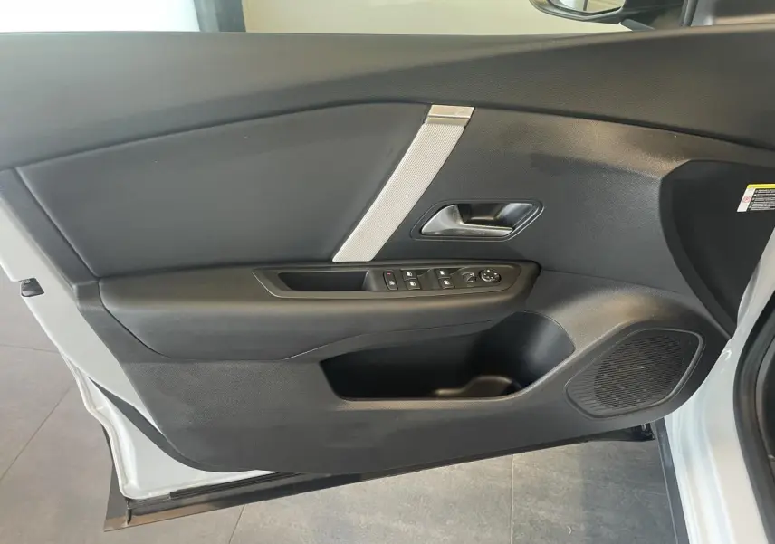 Porte avant gauche ouverte d'une Citroën C4 blanche métallisée, avec commandes de vitres et haut-parleur intégré.