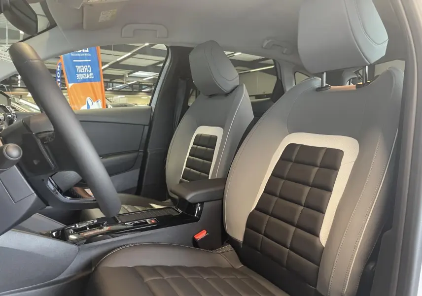Vue intérieure côté conducteur de la Citroën C4 2025, sièges Advanced Comfort bicolores noir et gris clair.