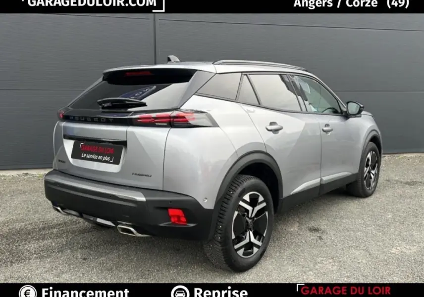 Vue 3/4 arrière droite d'un Peugeot 2008 Hybrid 136 e-DCS6 Allure gris clair avec jantes noires et détails noirs contrastants.