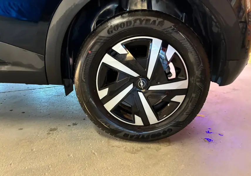 Gros plan sur la roue avant droite noire d’un Opel Mokka 1.2 Turbo 145 Edition 2025 avec jante au design géométrique bicolore.