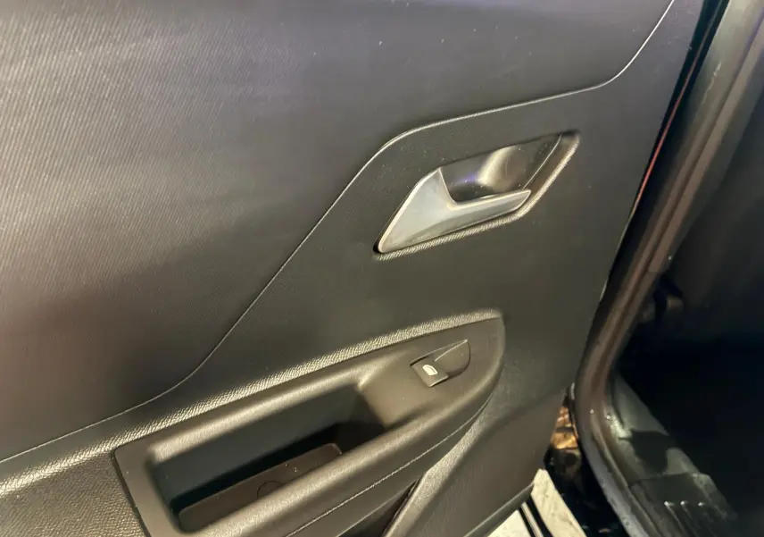 Gros plan sur la porte arrière droite noire de l'Opel Mokka 2025, montrant la poignée intérieure et le bouton de verrouillage.