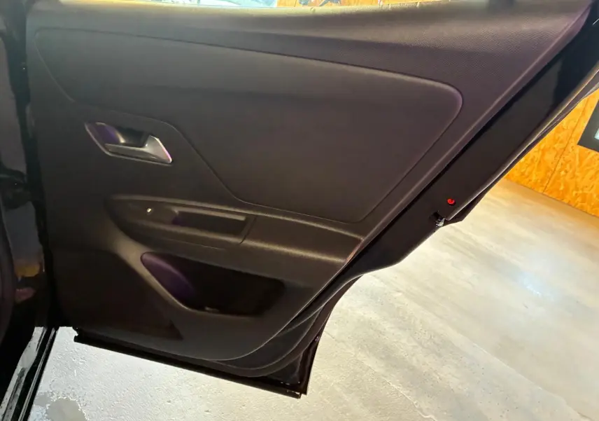 Vue rapprochée de la porte arrière gauche noire de l’Opel Mokka 2025, mettant en valeur la poignée intérieure et les rangements.