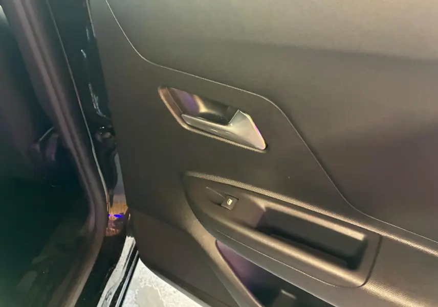 Gros plan sur la porte arrière gauche noire de l’Opel Mokka 2025, avec poignée argentée et bouton de verrouillage.