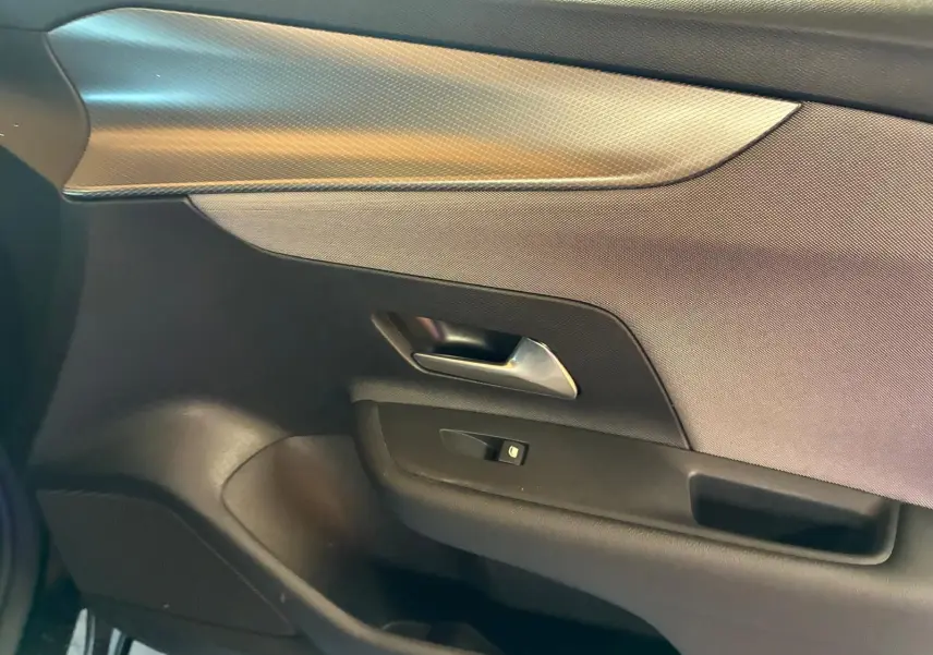 Détail de la porte intérieure côté gauche de l’Opel Mokka 2025, finition tissu noir avec poignée métallique.