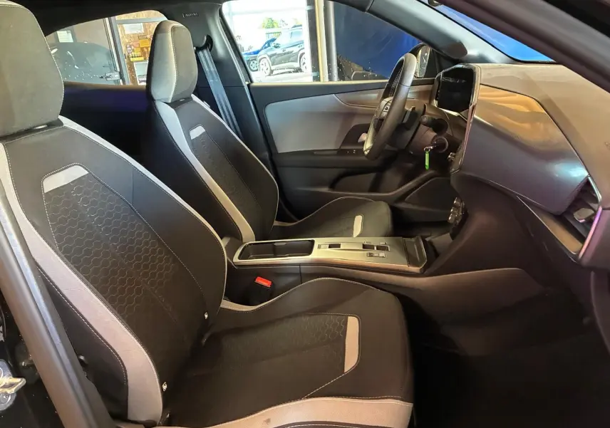 Vue intérieure côté droit de l'Opel Mokka 2025 noir, montrant les sièges tissu noirs et la console centrale moderne.