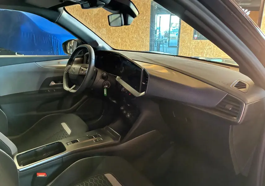 Intérieur noir de l’Opel Mokka 2025, vue côté conducteur, tableau de bord moderne avec écran tactile et volant multifonction.