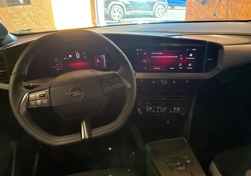 Vue intérieure du tableau de bord de l'Opel Mokka 2025 noire, avec volant multifonction et écran tactile large.
