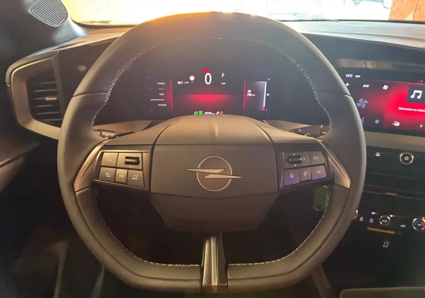 Vue frontale du volant noir de l'Opel Mokka 2025 avec tableau de bord numérique et écran tactile lumineux.