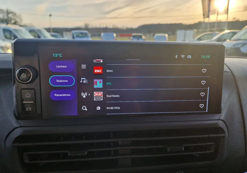 Écran tactile central du FIAT Scudo Fourgon blanc 2024 affichant les stations radio, vue intérieure frontale.