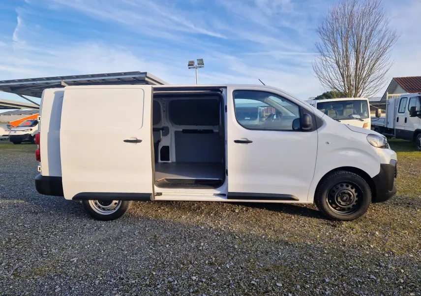 Vue de profil côté droit du FIAT Scudo Fourgon blanc 2024 avec porte coulissante ouverte montrant l’intérieur vide.