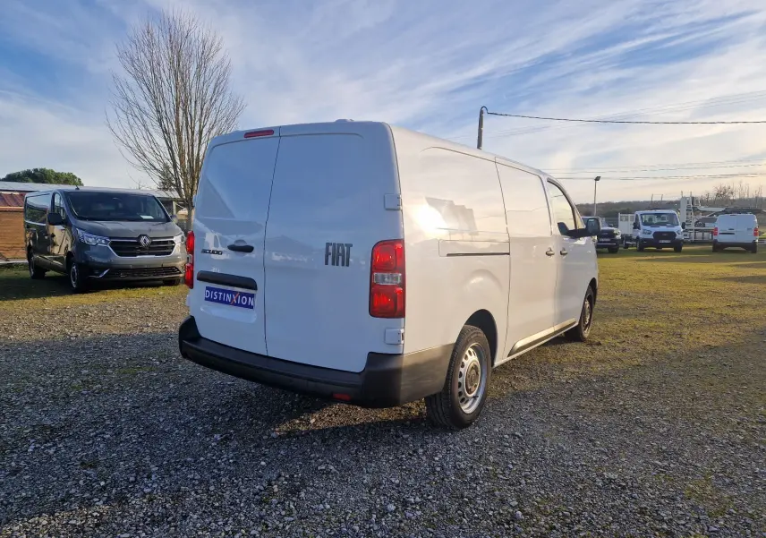 Vue 3/4 arrière droite d’un FIAT Scudo Fourgon blanc 2024 avec hayon arrière fermé sur un terrain extérieur.