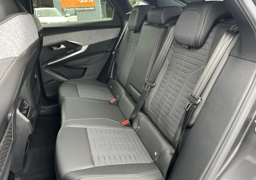 Vue côté droit des sièges arrière en cuir noir et tissu gris du Peugeot 3008 Nouveau hybride 2025 finition GT.