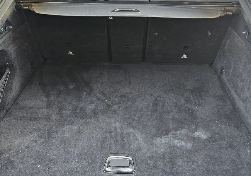 Coffre ouvert d'une Mercedes GLC 220 Coupé blanc de 2018, montrant un espace de chargement propre et tapissé noir.