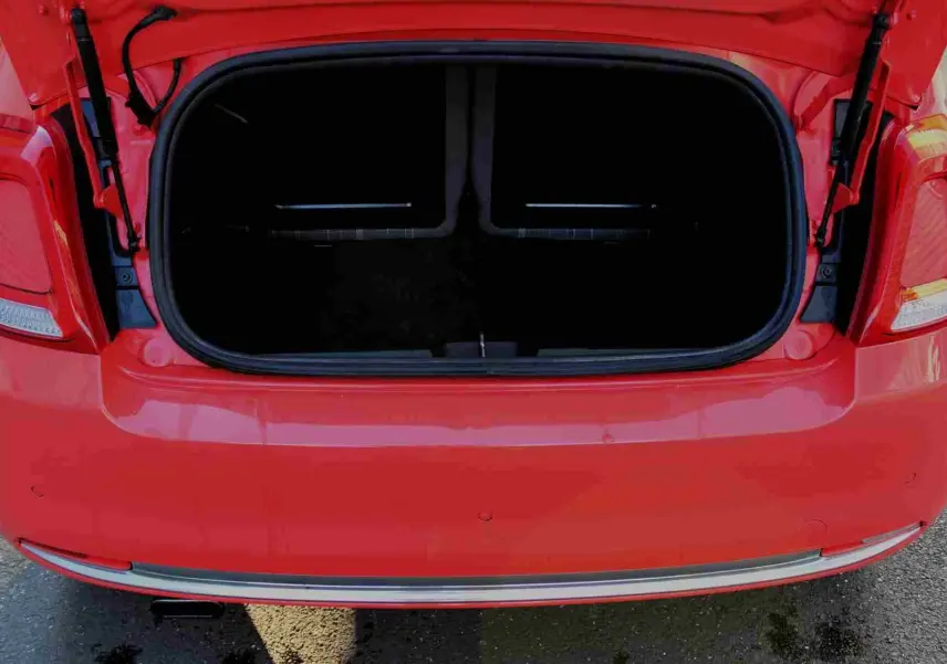 Gros plan sur la roue avant gauche d'une FIAT 500C rouge Pastel Coral avec jante argentée à rayons fins.