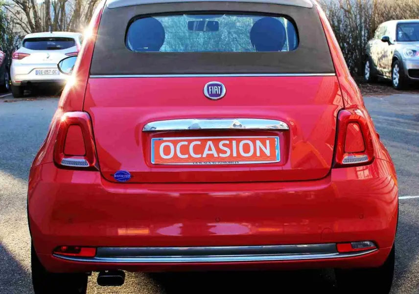 Vue frontale d'une FIAT 500C Pastel Coral Red 2018 avec toit ouvrant et plaque orange "OCCASION" visible.