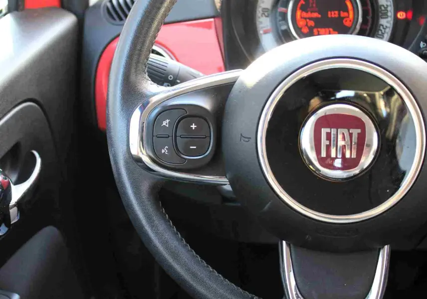 Tableau de bord de Fiat 500C 2018 en Pastel Coral Red, vue frontale centrée sur l'écran tactile et commandes.