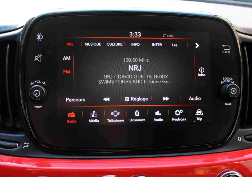 Écran tactile central de la Fiat 500C 2018 en Pastel Coral Red, affichant la radio NRJ en mode FM.