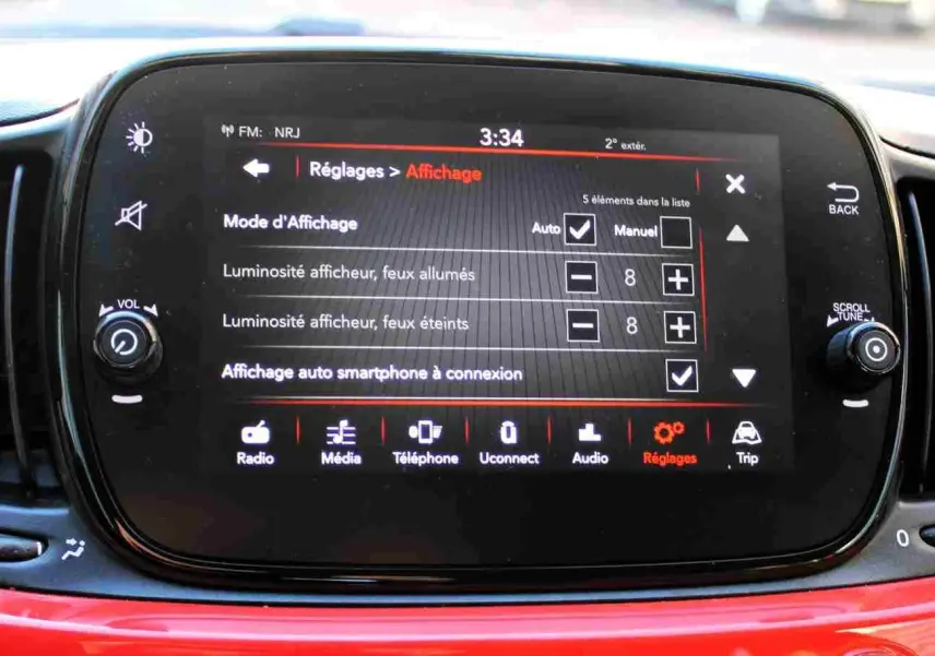 Écran tactile central de la Fiat 500C 2018 en Pastel Coral Red, affichant le menu Réglages et options d’affichage.