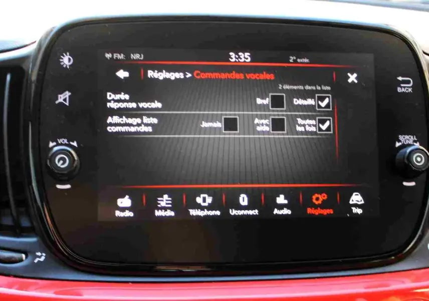 Écran tactile central de la Fiat 500C 2018 en Pastel Coral Red, affichant les réglages des commandes vocales.