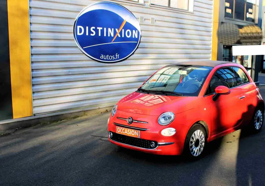 Vue arrière d'une FIAT 500C rouge Pastel Coral avec toit souple noir et plaque "OCCASION" visible.