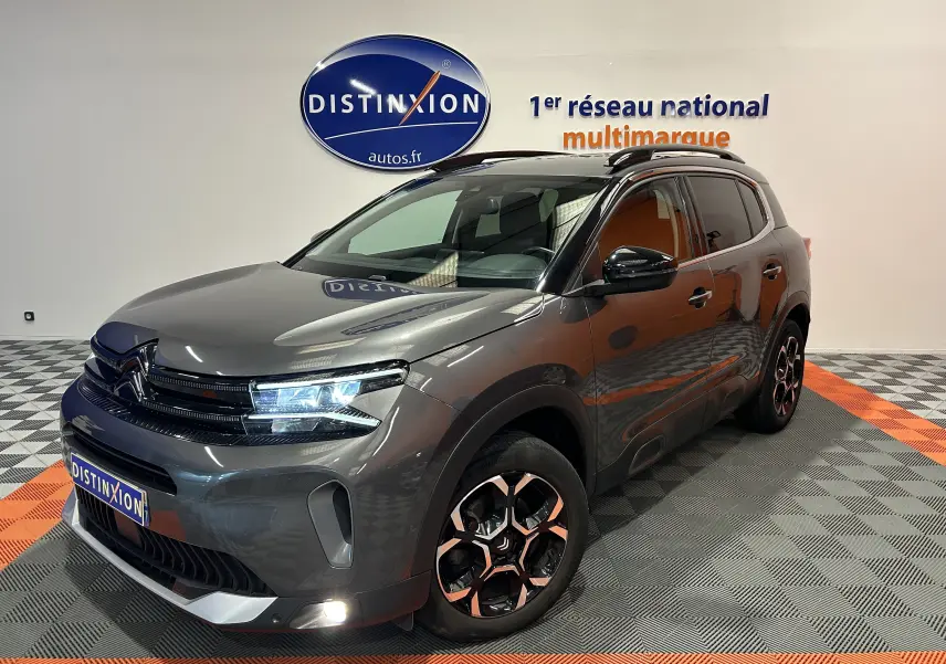 Citroën C5 Aircross gris Platinium en 3/4 avant droit, avec jantes noires et éclairage LED allumé.