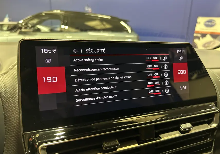 Écran tactile intérieur du Citroën C5 Aircross 2023 affichant les réglages de sécurité, avec une voiture grise en arrière-plan.