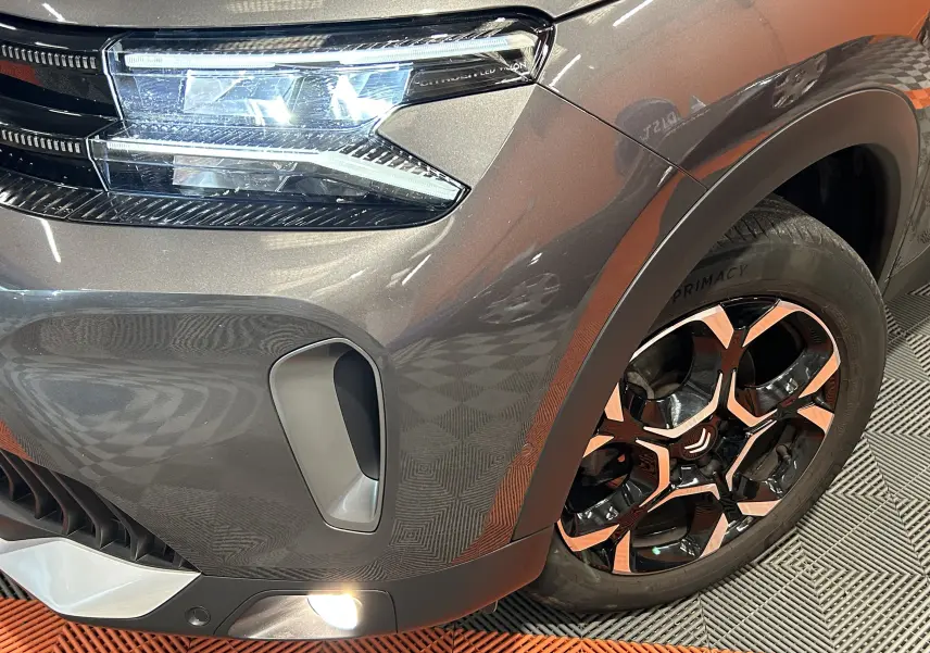 Gros plan sur l'avant droit gris Platinium du Citroën C5 Aircross avec phare LED et jante alliage bicolore.