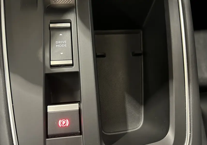 Détail de la console centrale grise du Citroën C5 Aircross avec bouton Drive Mode et frein à main électronique allumé.