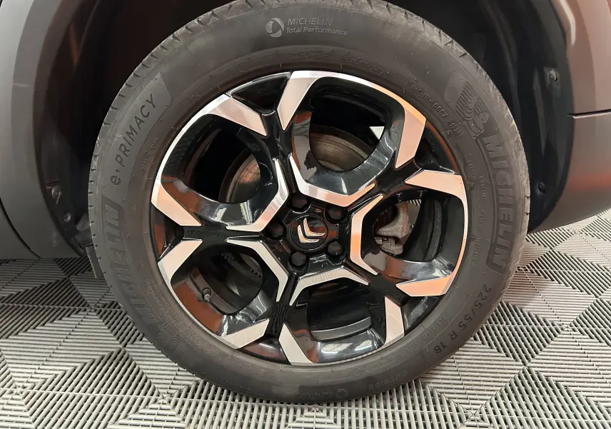 Gros plan sur la roue avant droite d’un Citroën C5 Aircross gris Platinium avec jante alliage noire et argentée.