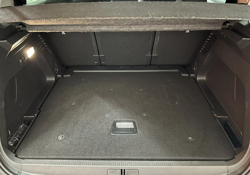 Vue intérieure du coffre spacieux et propre du Citroën C5 Aircross gris Platinium, avec éclairage latéral allumé.