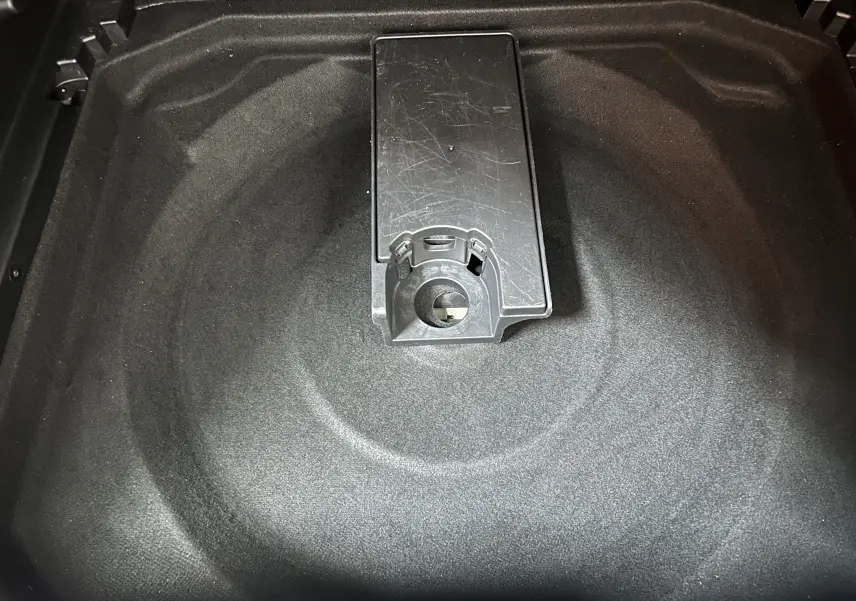 Coffre à roue de secours vide du Citroën C5 Aircross gris Platinium, vue plongeante sur le compartiment intérieur.