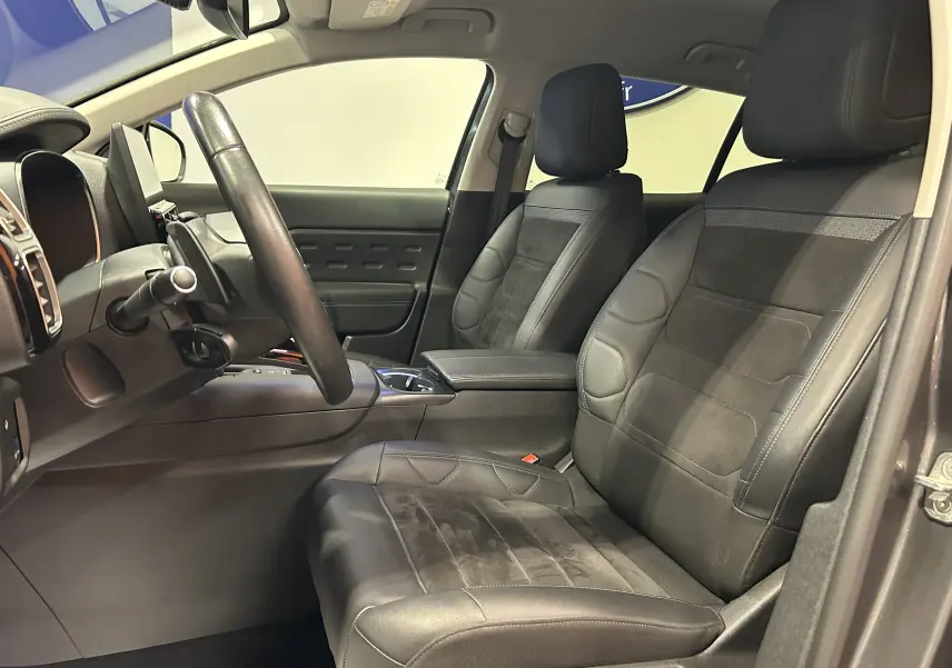 Vue intérieure côté conducteur du Citroën C5 Aircross 2023, sièges en cuir et alcantara noirs avec console centrale visible.