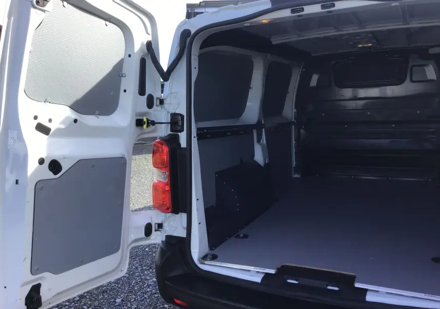 Vue arrière du FIAT Scudo Fourgon blanc 2024 avec portes ouvertes montrant l’espace de chargement vide et protégé.