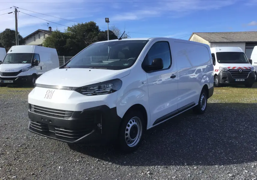 FIAT Scudo Fourgon blanc en 3/4 avant droit, avec pare-chocs noir et jantes acier, stationné sur un sol gravillonné.