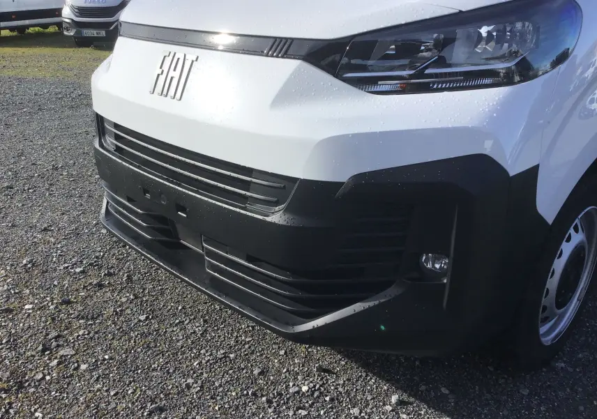 Gros plan sur l'avant droit du FIAT Scudo Fourgon blanc 2024 avec calandre noire et phares modernes.
