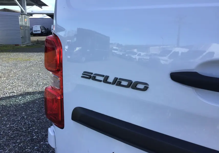 Gros plan sur l'arrière droit blanc du FIAT Scudo Fourgon 2024, avec feux rouges et logo Scudo visible.