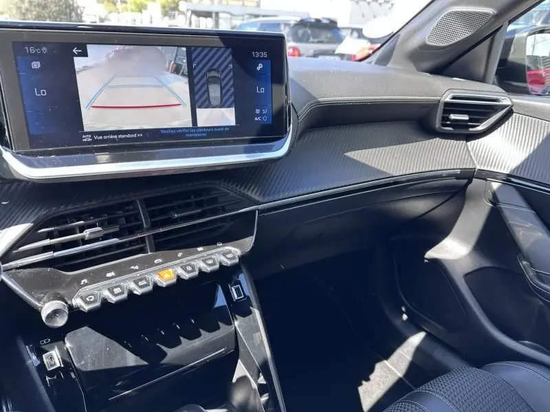 Vue intérieure côté passager du tableau de bord de la Peugeot 208 GT Line 2020 avec écran tactile et finition noire texturée.