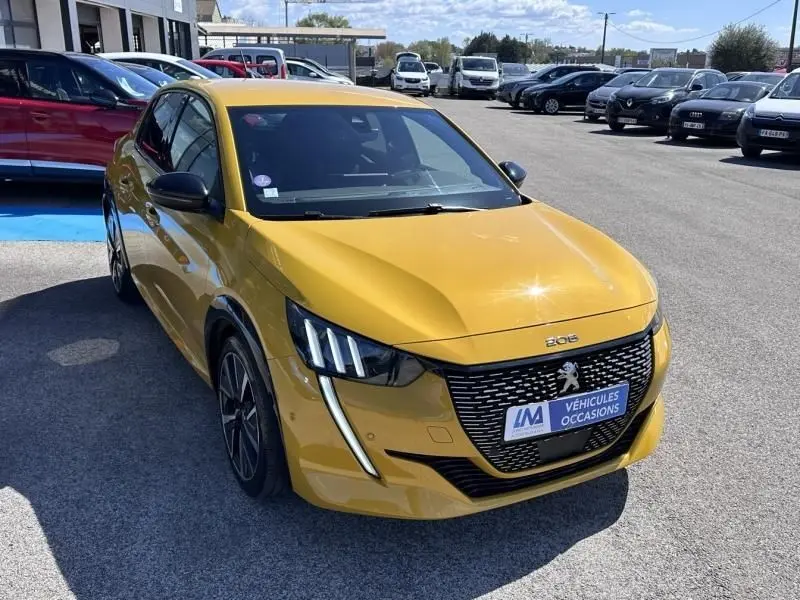 Peugeot 208 jaune faro vue 3/4 avant droit, avec calandre noire et feux LED distinctifs en forme de griffes.