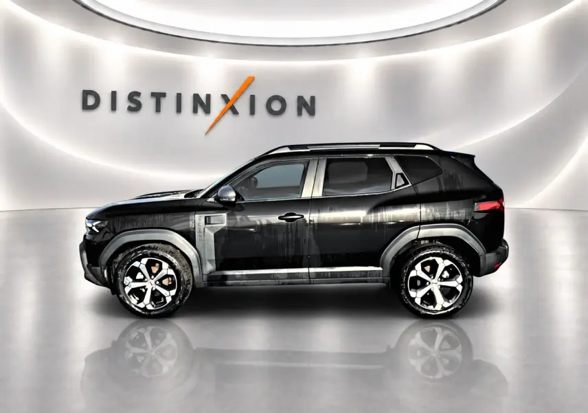 Profil côté gauche du Dacia Duster noir 2026 avec jantes alu et barres de toit, sur fond lumineux intérieur showroom.