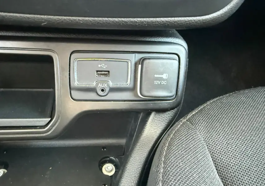 Gros plan sur la prise USB, prise auxiliaire et prise 12V dans l'habitacle noir du Jeep Renegade 2023.