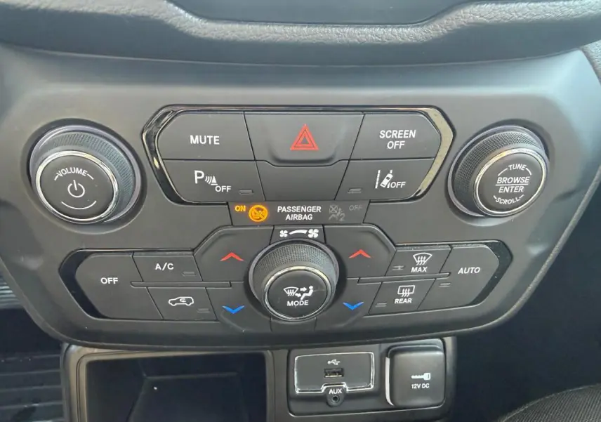 Vue rapprochée du tableau de bord central de la Jeep Renegade 2023, avec commandes climatisation et connectiques USB et 12V.