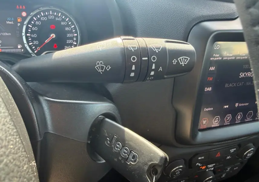 Gros plan sur la commande d’essuie-glace et le tableau de bord noir du Jeep Renegade 2023 avec clé insérée.