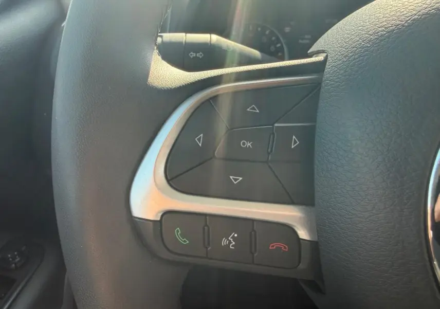 Gros plan sur les commandes du volant noir du Jeep Renegade 2023, avec boutons de navigation et appels.