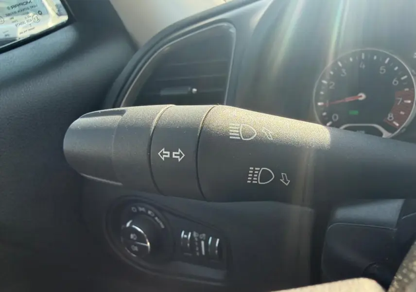 Gros plan sur la commande des clignotants et phares dans l’habitacle du Jeep Renegade bleu 2023.
