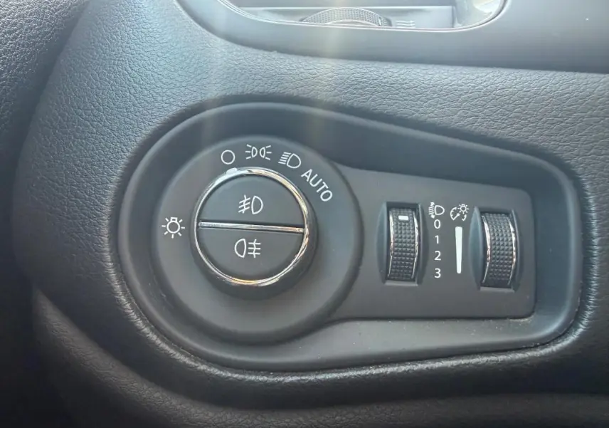 Gros plan sur les commandes d’éclairage du tableau de bord du Jeep Renegade 2023, finition Limited.