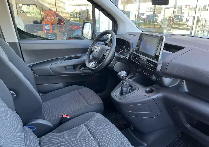 Intérieur du Toyota Proace City 2023 vu côté conducteur, avec tableau de bord moderne et console centrale équipée d'un écran tactile.