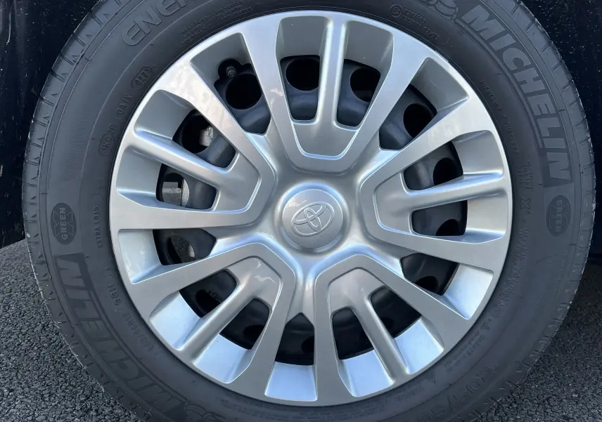 Gros plan sur la jante argentée avec logo Toyota, montée sur un pneu Michelin d'un Toyota Proace City blanc glacier.