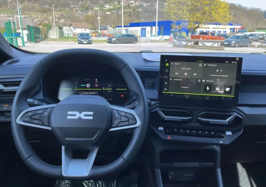 Vue intérieure centrée sur le volant cuir et l’écran tactile 10,1 pouces du Dacia Bigster gris schiste 2026.