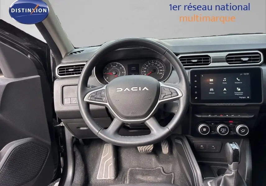 Vue intérieure centrée sur le volant DACIA noir et le tableau de bord avec écran tactile du Duster 2024.