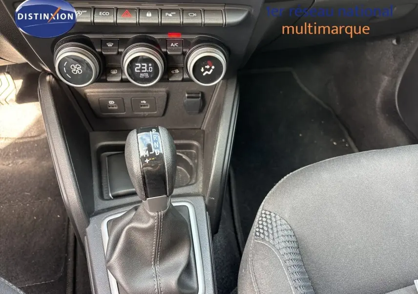Gros plan sur la console centrale du Dacia Duster noir 2024, avec levier de boîte auto et commandes de climatisation.